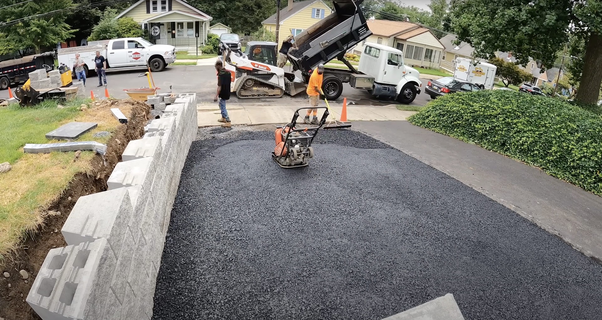 Active residential driveway construction project with equipment and crew working in Henderson, KY