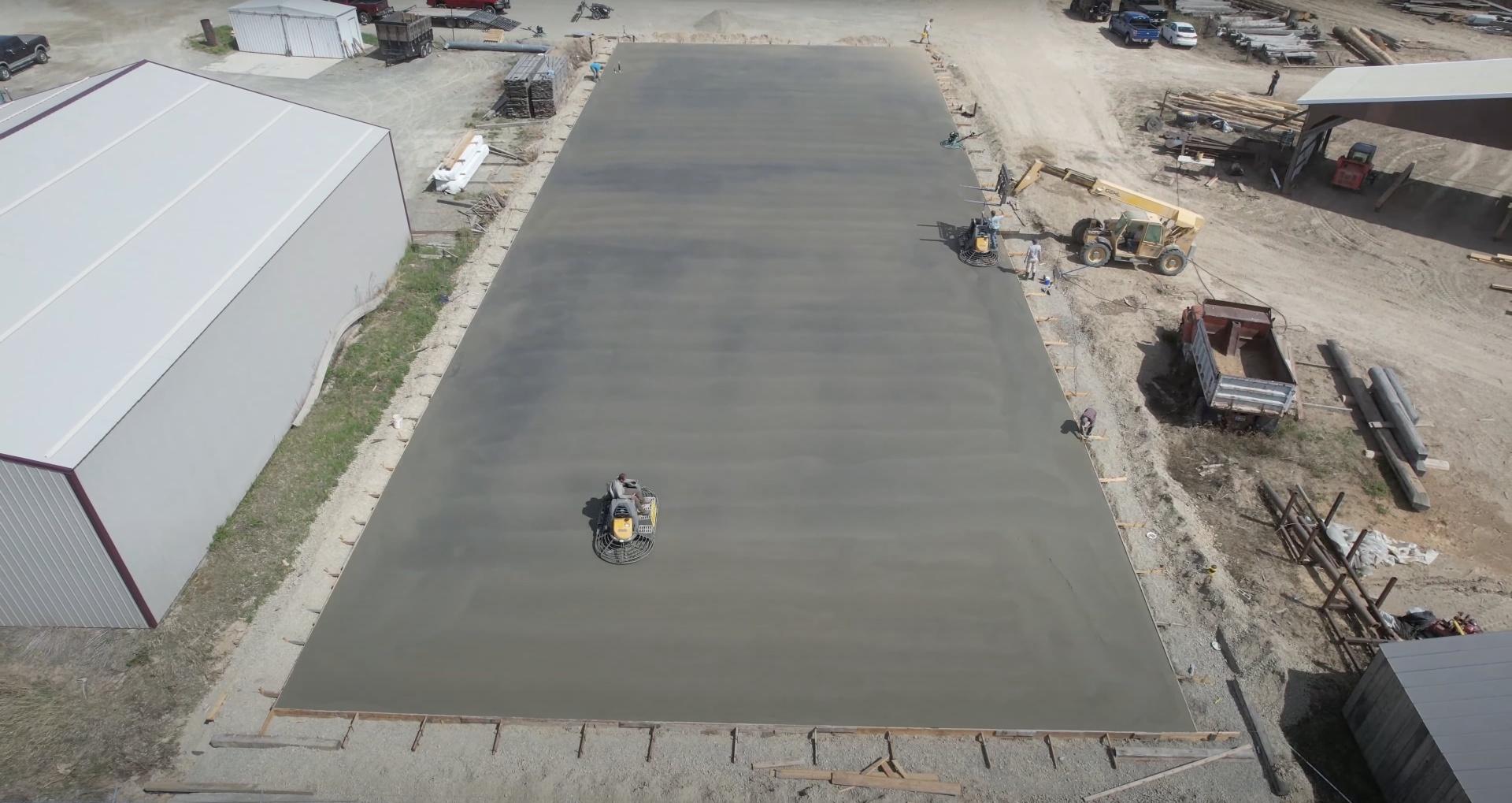 Large-scale commercial concrete slab installation aerial view showing professional equipment and crew in Henderson, KY